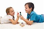 Happy kids - boy and girl - playing on the floor with puppets - isolated
