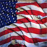 Flag of the United States, fluttering in the breeze, backlit rising sun. Sewn from pieces of cloth, a very realistic detailed flags waving in the wind, with the texture of the material, isolated on a white background