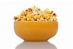 Delicious popcorn in yellow ceramic bowl over white background.