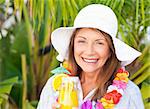 Retired woman drinking a cocktail under the sun