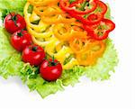 Mix of fresh vegetables from a colored paprika on leaves of green salad on a white background