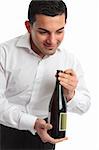 A waiter or servant presenting a bottle of wine.  White background.