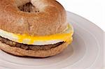 Sausage, Egg and Cheese Breakfast Bagel Close Up on a Plate.