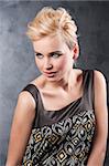 young blond fashion woman with creative hairstyle and make up on dark background