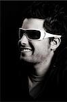 Attractive male wearing sunglasses against black background