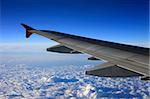 Wing of the plane on a background of clouds