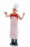 A young six year old chef in apron and chef hat holding a kitchen utensil.  White background.