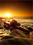 Beautiful colorful sunset over sea and boulders on Sri Lanka