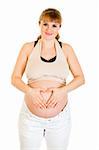 Smiling pregnant woman making heart with her hands on tummy isolated on white