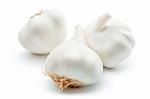 Three cloves of garlic arranged on a white background close-up