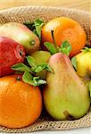 Fresh fruit apples pears tangerines and mint sprigs