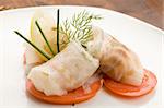 photo of delicious sea bass rolls on sliced tomatoes