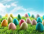 Colorful Easter eggs in a field of grass with blue sky