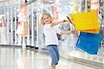 A little girl with the packages in the shop