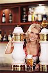 Young attractive girl pours a beer at the bar