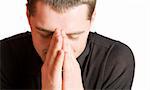 Young man praying with eyes closed closeup isolated on white