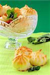 Cake profiteroles  in a crystal vase on a green background