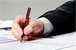 Male hand is writing in business document