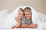 Couple lying down in their bed at home