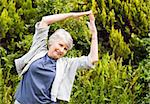 Mature woman doing her streches in the garden