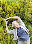 Mature woman doing her streches in the garden