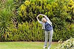 Mature woman doing her streches in the garden