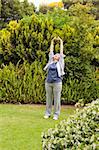 Retired woman doing her streches in the garden