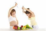 Two women are preparing to attack the fruit and vegetables isolated on white