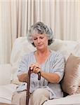 Woman with her walking stick at home