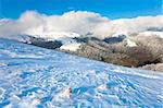 October mountain view with first winter snow and last autumn colourful foliage on far mountainside