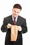 Disappointed businessman having to bring his lunch in a bag to save money.  Isolated.