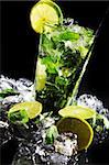 Fresh drink with ice, green mint and lime on black background