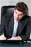 handsome middle aged businessman is sitting in chair at his cabinet