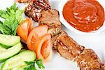 Fried kebab meat with vegetables and sauce