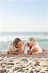 Mature couple lying down on the beach