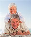 Senior couple lying down on the beach