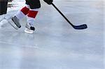 Legs of young child playing outdoor pond hockey