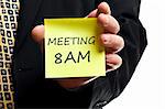 Meeting at 8AM post it in business man hand