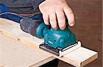 A man working with electrical sanding machine, close up on tool, hands and sparks, real situation picture