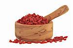 Goji berries in an olive wood mortar with pestle isolated over white background.