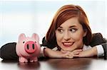 Young businesswoman with her piggy bank.