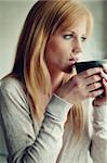Pretty young woman drinking a cup of coffee