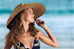 Summer portrait of woman in hat near ocean