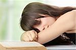 Sleeping while learning - tired teen woman sleeping on desk