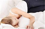 Cute young woman sleeping on the bed in casual clothes