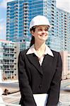 Woman with skyline in background working in construction