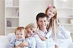 Young happy family with two children at home