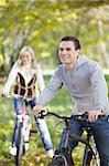 Couple cycling in autumn park