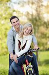 Laughing couple on a bike in the autumn park