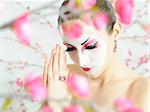 japan geisha woman with creative make-up in sakura garden.close-up artistic portrait